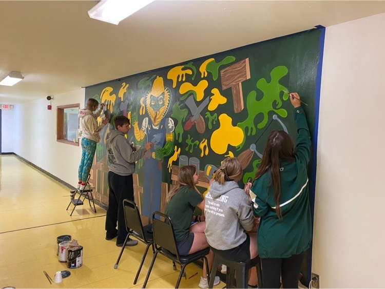 students help paint a mural 